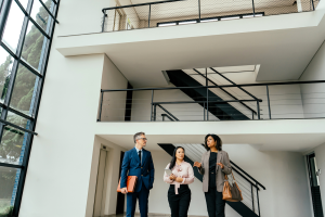 Commercial real estate professionals touring a modern office building while discussing a property transaction.